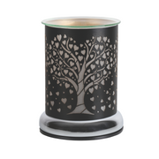 Elegant electric wax melt warmer with a cutout tree and heart design on black metal. Glass top and chrome shiny base, conveying warmth and sophistication.