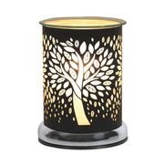 A black cylindrical electric wax melt warmer, adorned with a tree cutout design, glowing warmly. The metal surface contrasts with the soft light, creating a cosy ambiance.