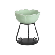 Elegant green ceramic wax melt bowl with scalloped edges on a black metal stand. The modern design conveys simplicity and sophistication.