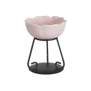Elegant pink ceramic wax melt bowl with scalloped edges on a black metal stand. The modern design conveys simplicity and sophistication.