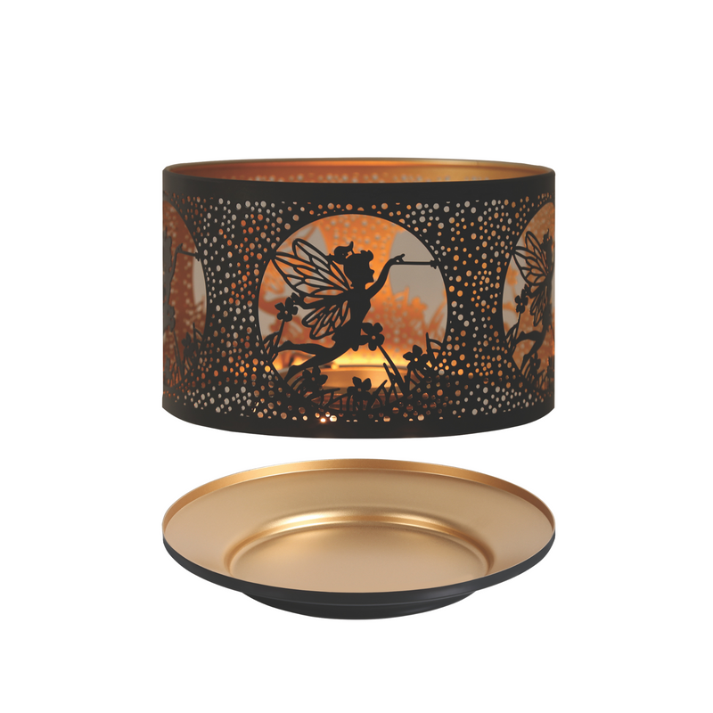 A decorative black and gold candle shade with intricate cut-out silhouettes of a fairy and flowers against a warm glowing background. It includes a matching candle tray.