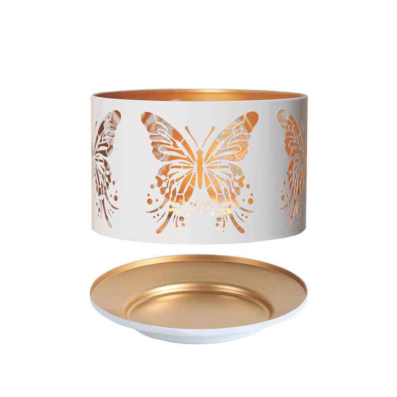 White cylindrical candle shade with intricate butterfly cutouts, revealing golden interior light. Below, a matching gold plate conveys elegance and warmth.