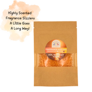 Brown bag with clear window showing orange fragrance sizzlers. Label reads "Sol Holiday Vibes." Text: "Highly Scented Fragrance Sizzlers. A Little Goes A Long Way!" Cozy and inviting vibe.