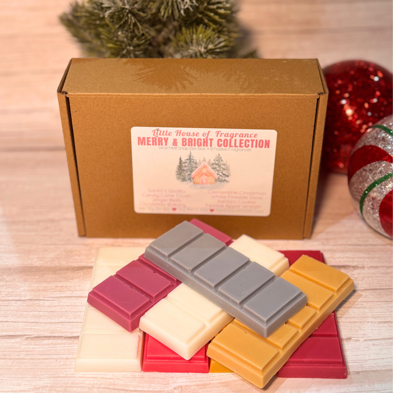 Collection of wax melts in front of a 'Little House of Fragrance' box with Christmas decorations.