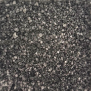 Close-up view of coarse black fragrance scent sizzlers  with a rough texture, resembling gravel or charcoal, filling the image. The tone is neutral and industrial.