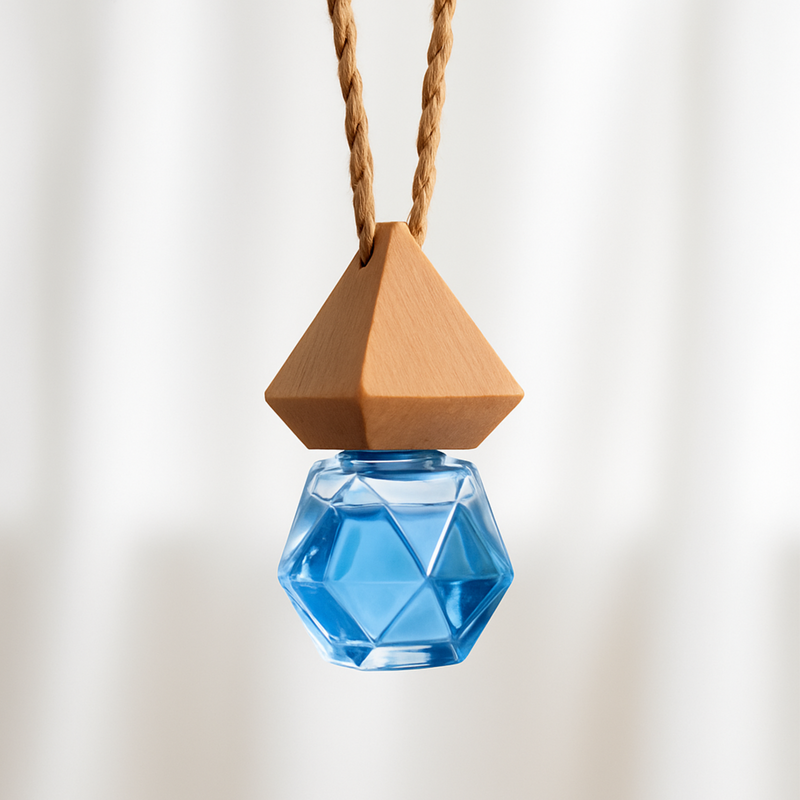 Hanging geometric blue glass bottle with wooden cap, suspended by a twisted rope against a soft beige background. Minimalist and elegant design.