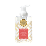 A clear bottle of Michel Design Works Rosé Mimosa foaming hand soap with shea butter, featuring a gold and white geometric design and a dark pink label.