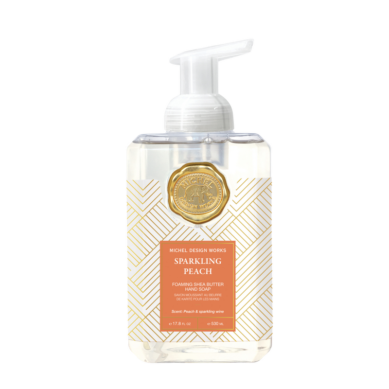 A rectangular bottle of Michel Design Works Sparkling Peach foaming hand soap with a gold chevron pattern label and a gold seal above.